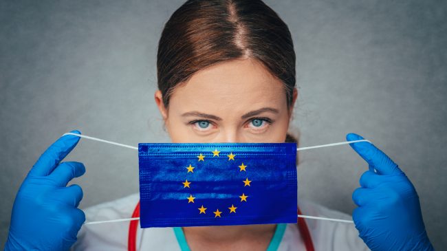 Coronavirus in European Union, Female Doctor Portrait hold protect Face surgical medical mask with Europa Union Flag. Illness, Virus Covid-19 in EU, concept photo