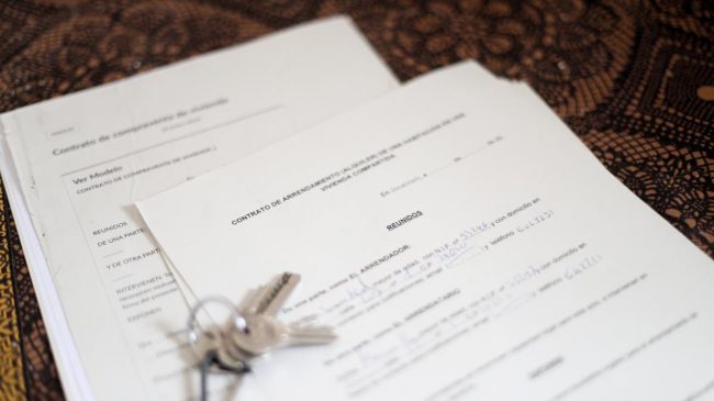 unas-llaves-sobre-un-contrato-de-compraventa-de-vivienda-y-un-contrato-de-arrendamiento-alquiler-de-una-habitacion-en-una-vivienda-compartida