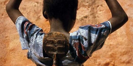 Niño con muñeca en la espalda Niño con muñeca en la espalda