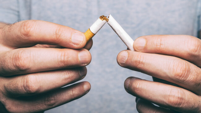 Quitting smoking – male hand crushing cigarette