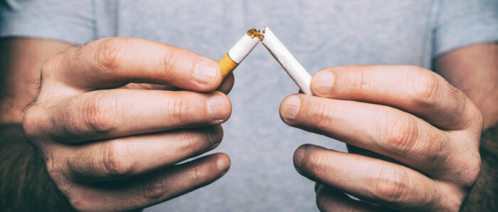 Quitting smoking – male hand crushing cigarette