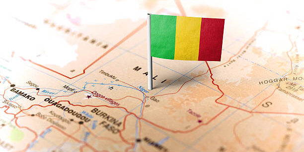 The flag of Mali pinned on the map. Horizontal orientation. Macro photography.