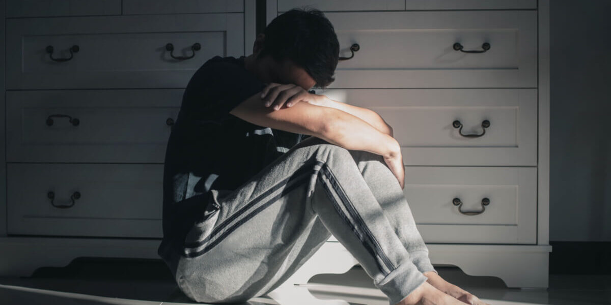 hombre-suelo-habitacion-triste